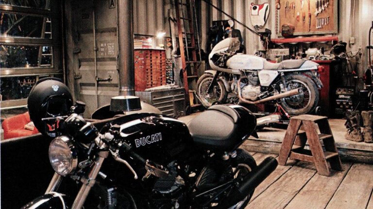 Custom Ducati motorcycle in workshop with tools and bikes – expert Custom Car And Motorcycle Builds by Piston Hymn Customs.