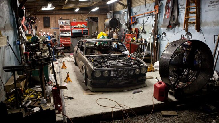 Classic car restoration in gritty garage workshop – tools, parts, and expert Custom Car And Motorcycle Builds in progress.